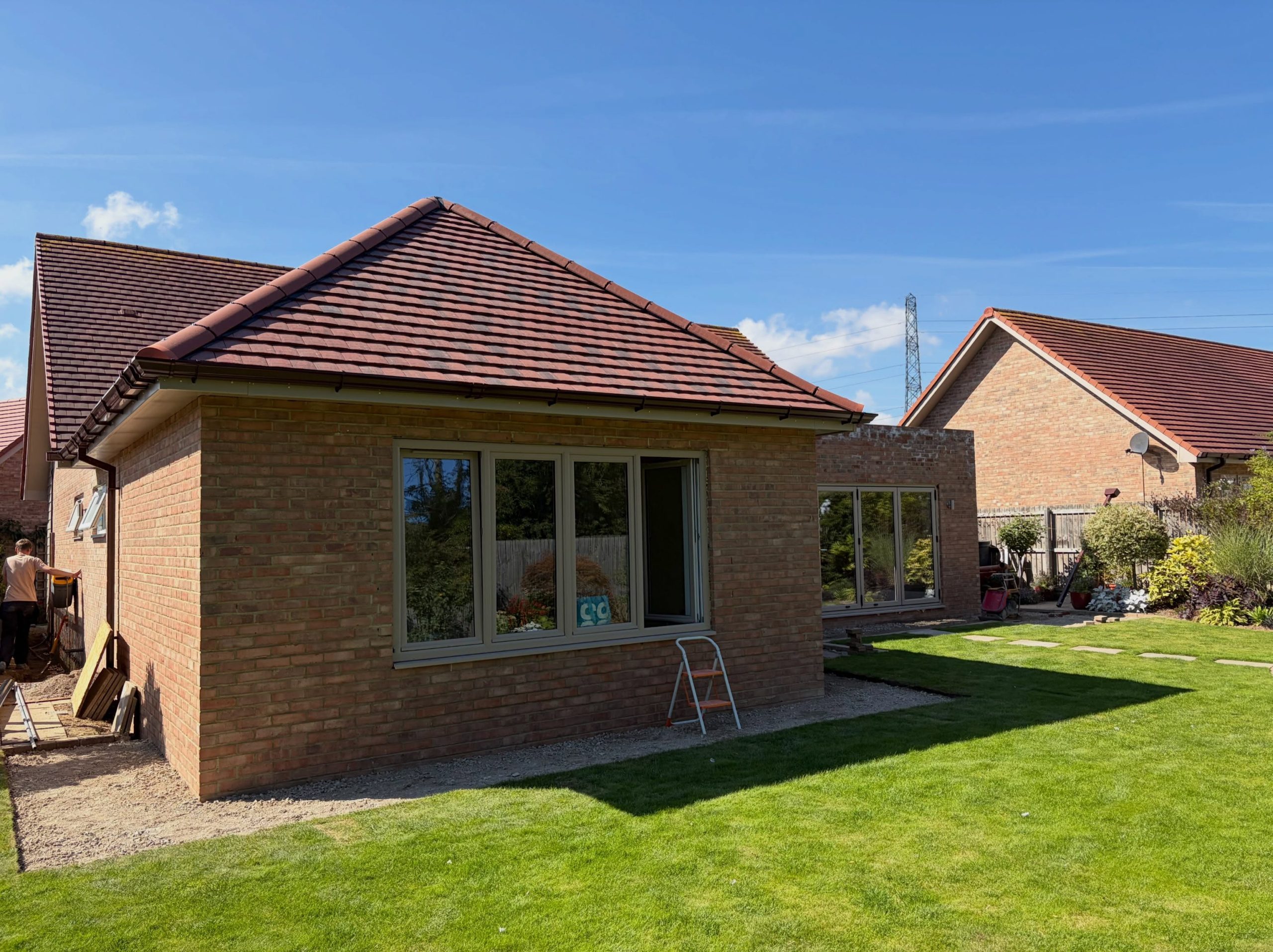 Finished brick home extension with traditional hipped tiled roof Finished brick home extension with traditional hipped tiled roof